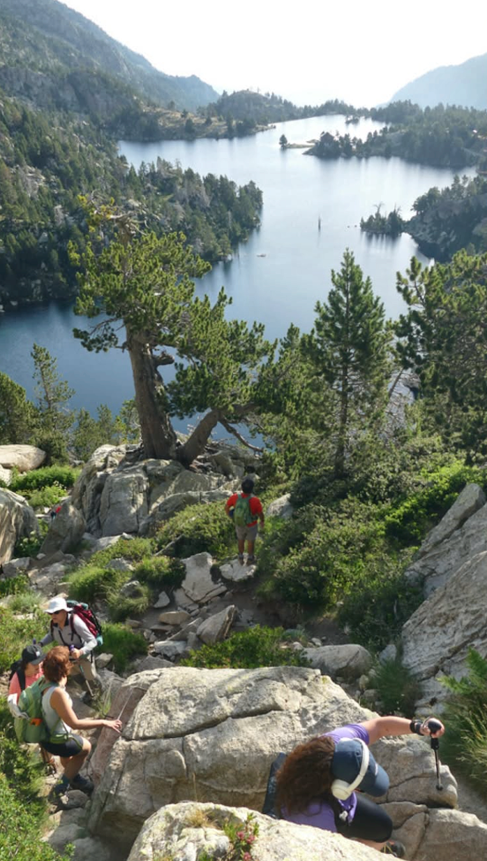 Senderistes en un camí rocós amb un llac al fons