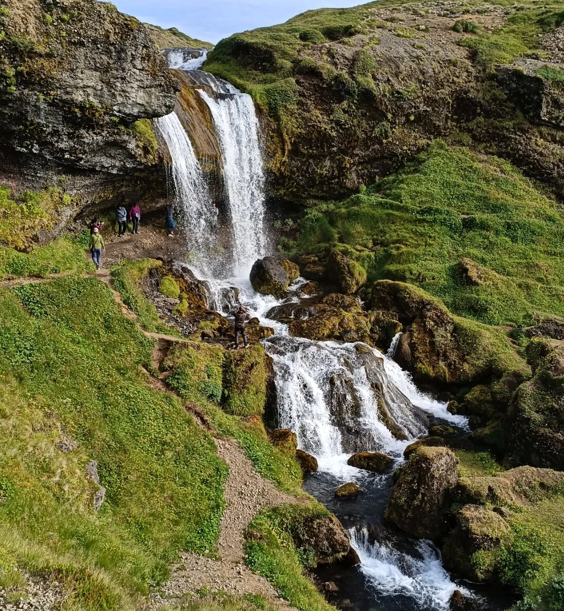 Excursionistes al costat d'una cascada